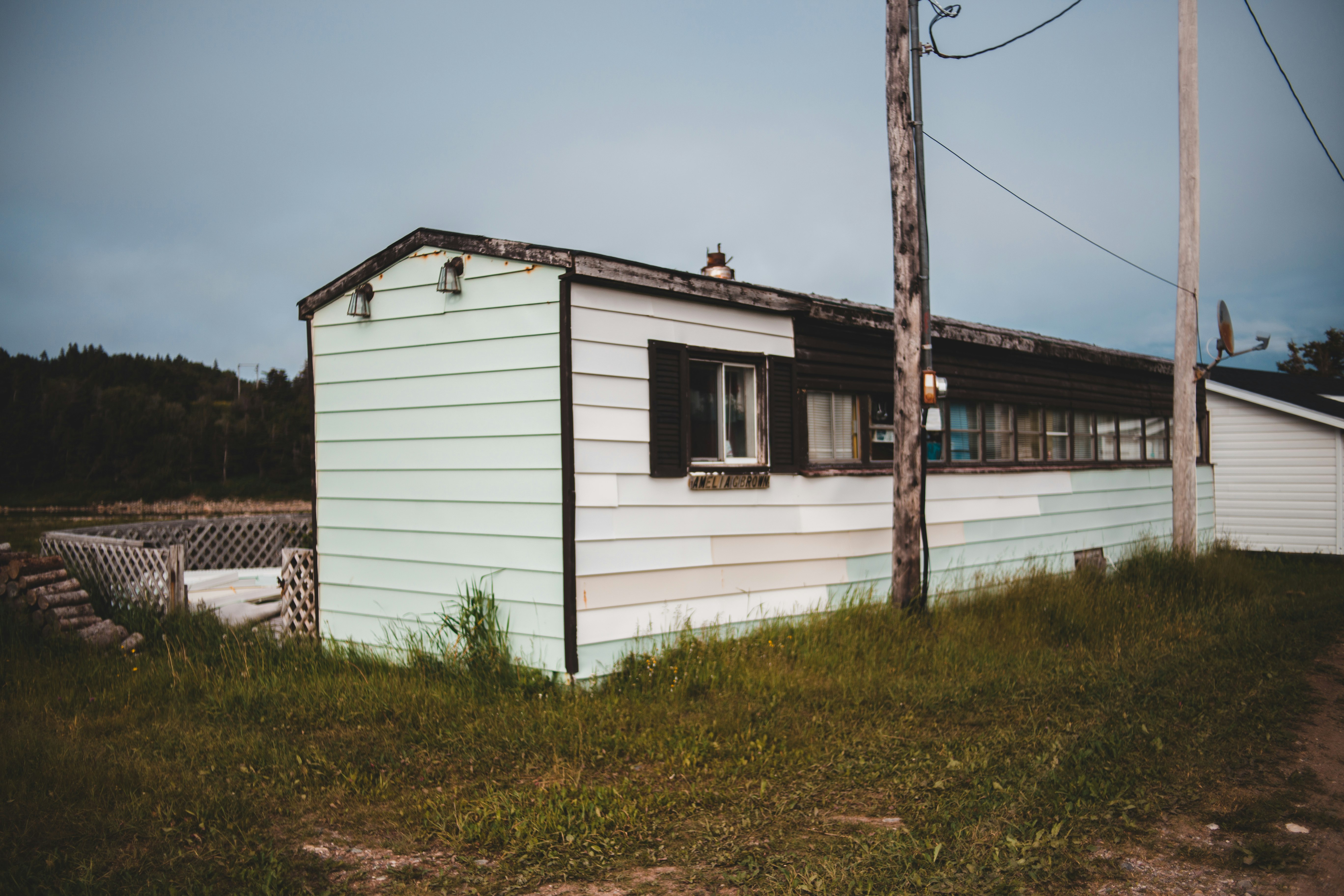 white and brown wooden house near green grass field during daytime